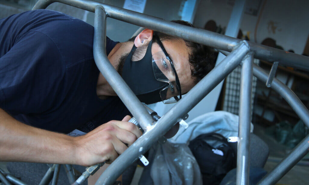 Mechanical engineering student Bodhi Edwards works on the frame of the Cal Poly Baja Car